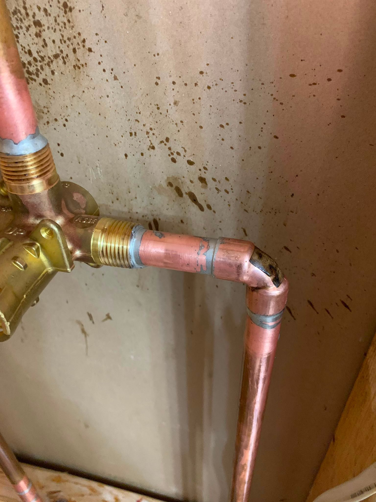 Close-up of a corroded copper pipe joint highlighting the need for professional plumbing repairs and