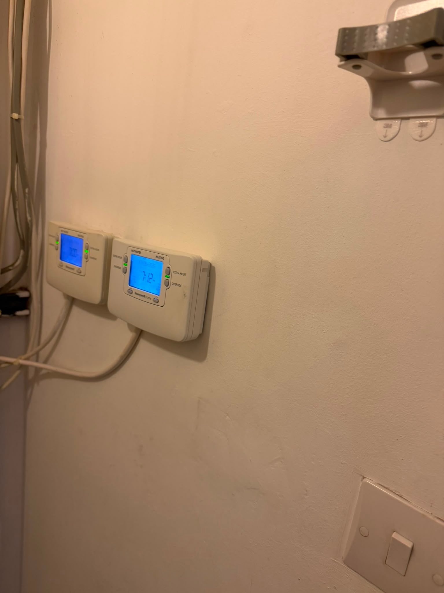 Two modern thermostats mounted on a white wall, showcasing KOZ Plumbing & Heating’s expertise in