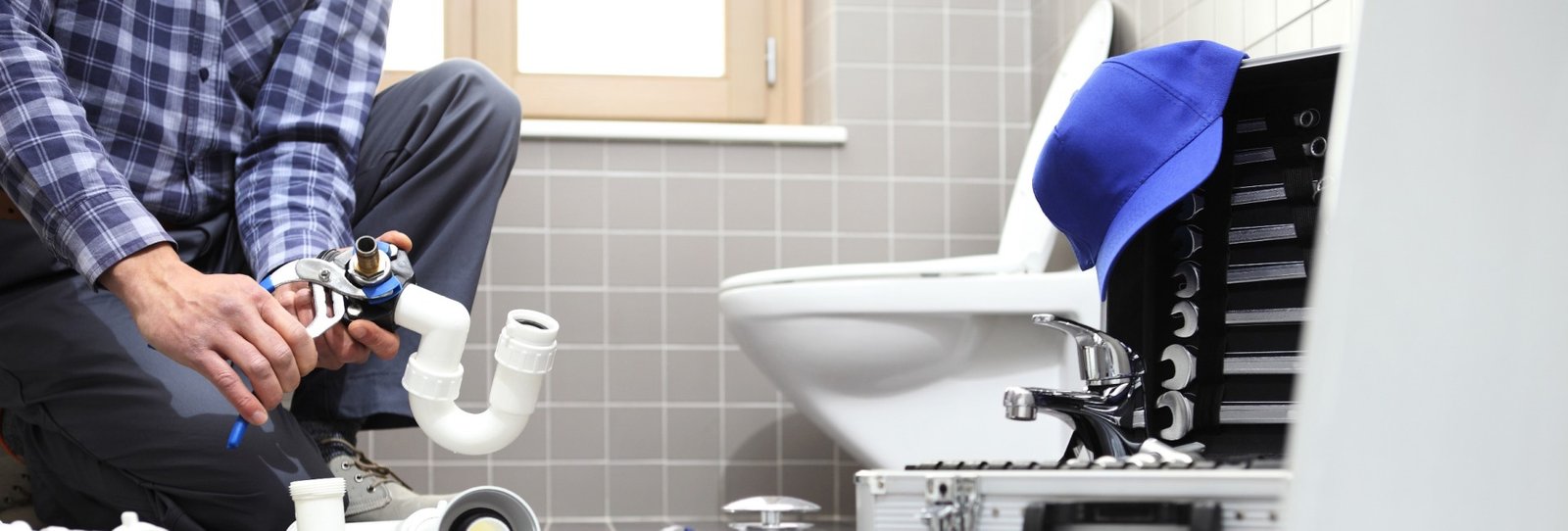 Plumber working on bathroom plumbing repairs and installations in London.