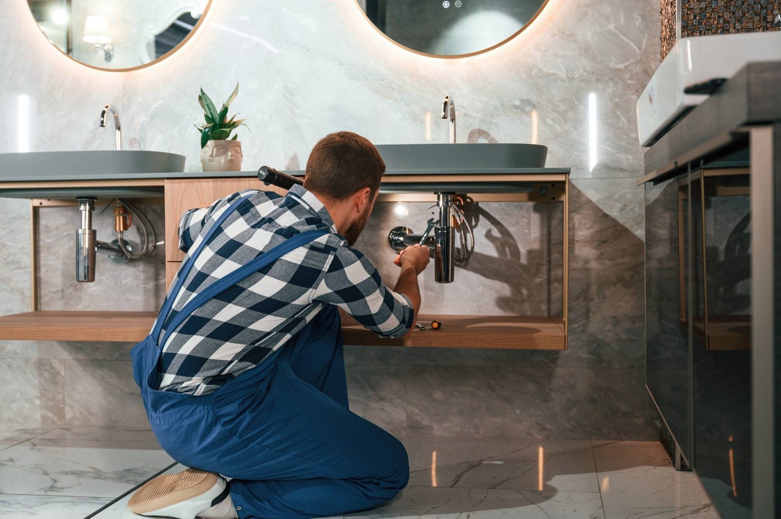 KOZ Plumbing & Heating technician in London repairs a bathroom siphon, demonstrating expertise in toilet