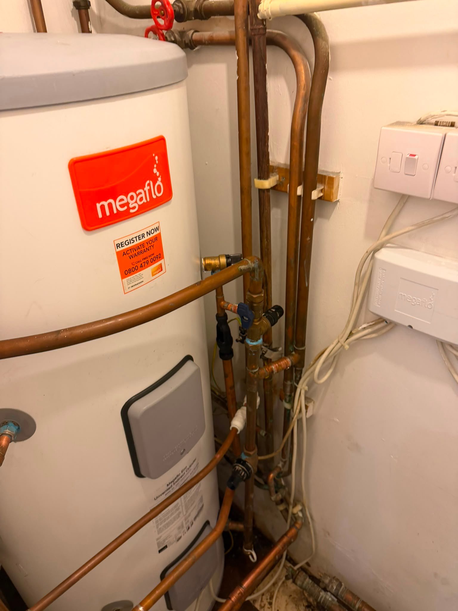 Close-up of a modern Megaflo water tank with copper piping, showcasing KOZ Plumbing & Heating's