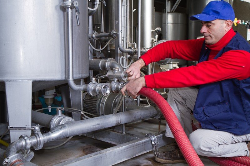 Heating engineer working on boiler piping, showcasing KOZ Plumbing & Heating’s expertise in central heating