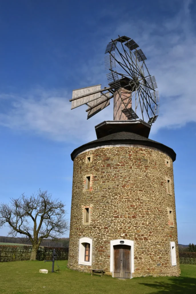 Historic stone windmill with turning sails, symbolizing reliable and established service from KOZ Plumbing &