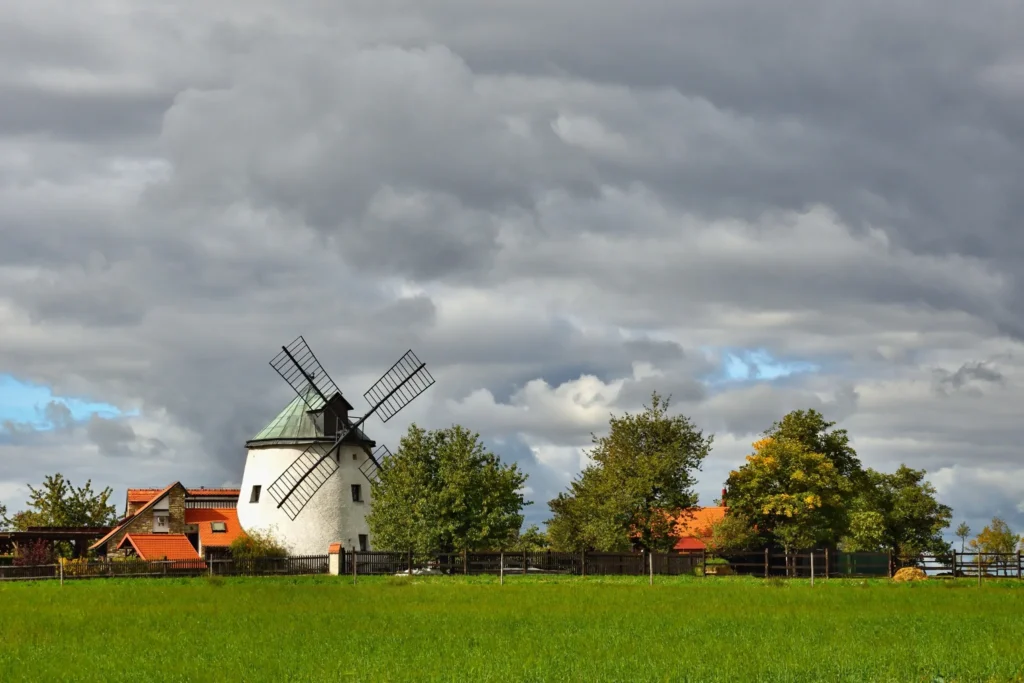 Traditional windmill in a European landscape, evoking reliability and enduring solutions, reflecting KOZ Plumbing &