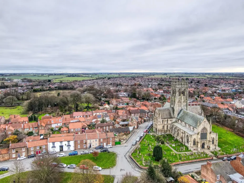 Overhead view of a historic townscape with a prominent church steeple, representing the service area