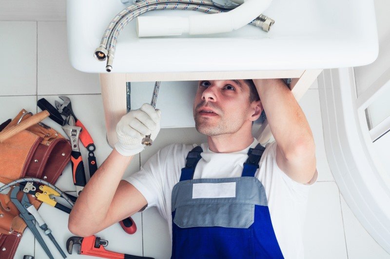 Plumber working on a sink installation, demonstrating KOZ Plumbing & Heating's expertise in general plumbing