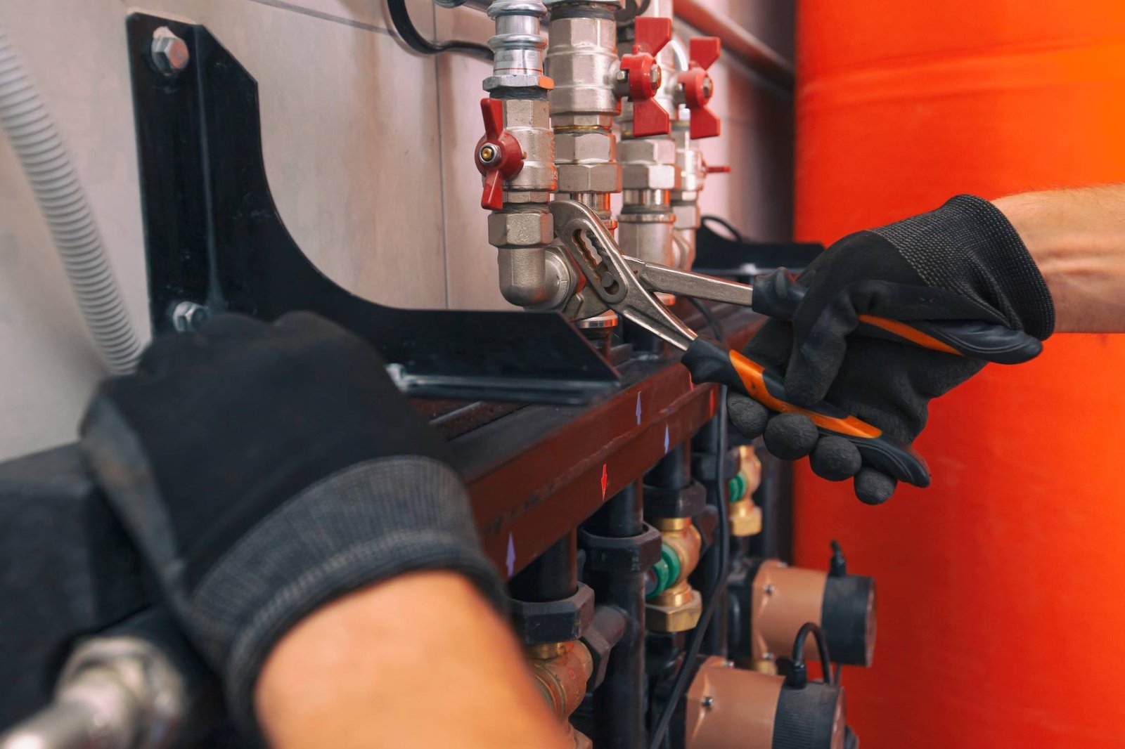 KOZ Plumbing & Heating technician using a wrench to service a heating system component in