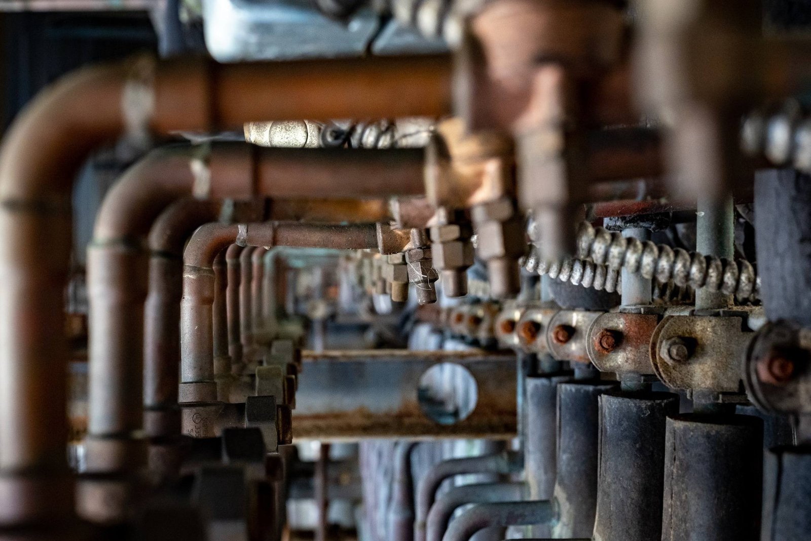 Weathered, rusty pipes and valves representing complex plumbing systems, highlighting KOZ Plumbing & Heating’s expertise